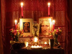 A Christian shrine featuring images of Christ and St Francis with candles